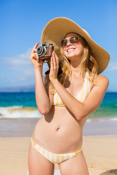 Beautiful Woman at the Beach with Camera - 写真・画像