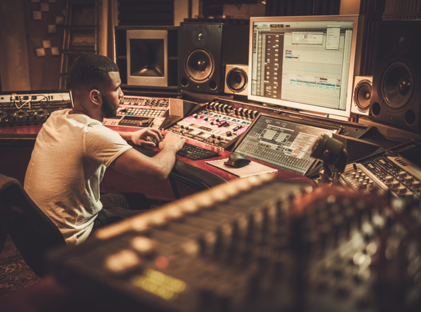ブティックのレコーディング スタジオでパネルを混合で働くアフリカ系アメリカ人のサウンド エンジニア - 写真・画像