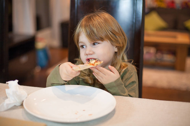 手でピザを家で食べる子 - 写真・画像