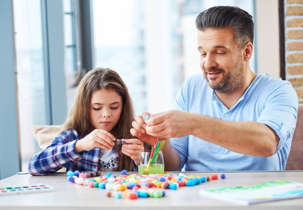 schönes kleines Mädchen mit ihrem Vater beim Spielen mit farbigem Set für Kreativität - Foto, Bild