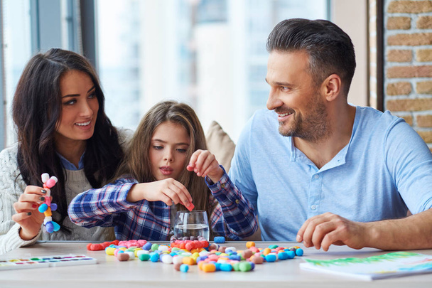 fröhliche Familie spielt mit farbigem Set für Kreativität - Foto, Bild