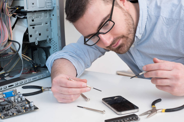 Expert technician is repairing a broken smart-phone - Foto, Bild