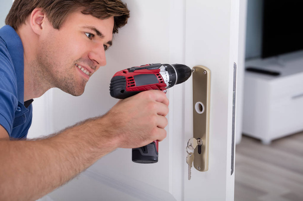 Young Male Installing Door Lock - Foto, Bild