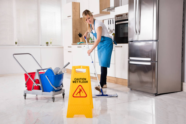Woman Cleaning Kitchen Floor - Фото, зображення