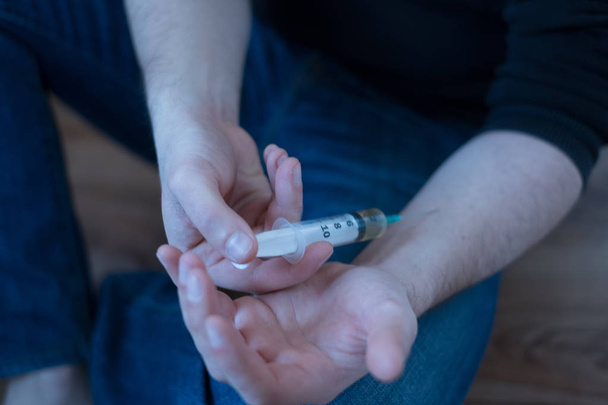 Hombre drogadicto inyectándose heroína en su brazo
 - Foto, Imagen
