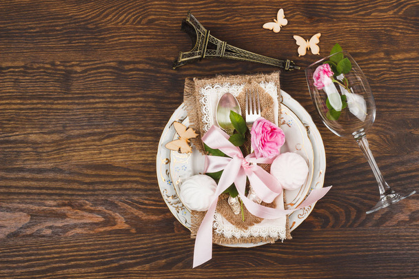 Light pink roses and tableware on the wooden table - Фото, изображение