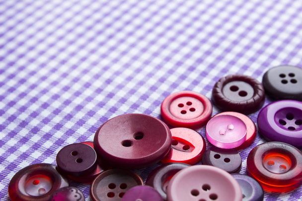 Um monte de botões coloridos brilhantes no tecido, costura
. - Foto, Imagem