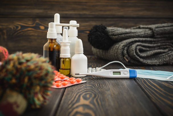 Pills, nose drops a cold treatment, flu runny  on the table with an electronic thermometer - Foto, immagini
