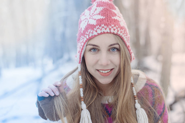 Image filtrée colorée. Portrait d'hiver de jeune belle femme blonde portant un chapeau tricoté. Neiger hiver beauté mode concept. Forêt enneigée sur fond
. - Photo, image