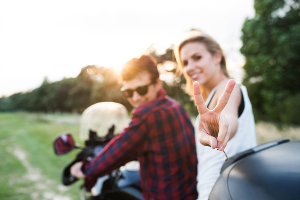 Couple in love enjoying a motorbike ride in countryside. - Foto, afbeelding