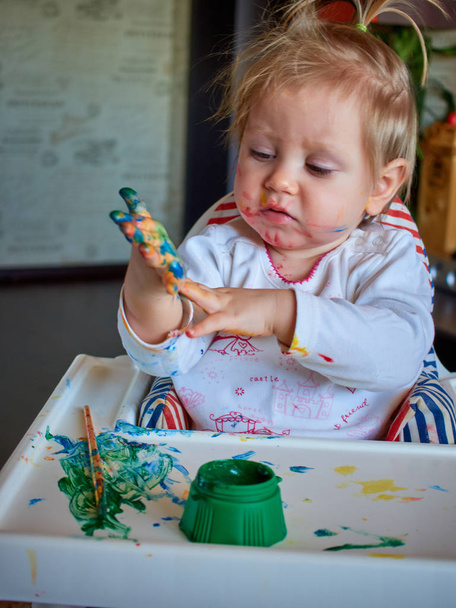 Cute little girl painting with brush. - Foto, Imagen