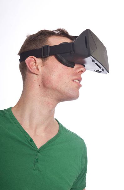 Young man with virtual reality glasses on white background - Foto, afbeelding