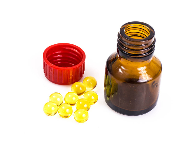 Farmácia Vitaminas: cápsulas de gelatina redondas em uma garrafa de g escuro
 - Foto, Imagem