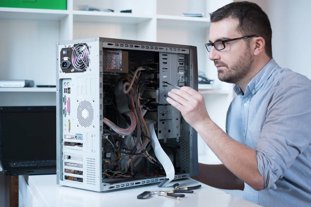 Professioneller Mann repariert und montiert einen Computer - Foto, Bild