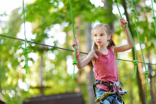 girl climbing in adventure park - Foto, afbeelding