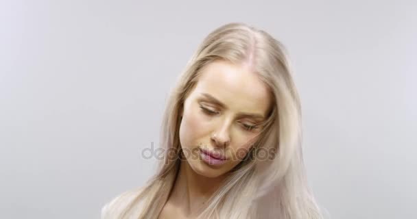 Slow motion studio portrait of a blonde womans hair blowing in the wind - Felvétel, videó