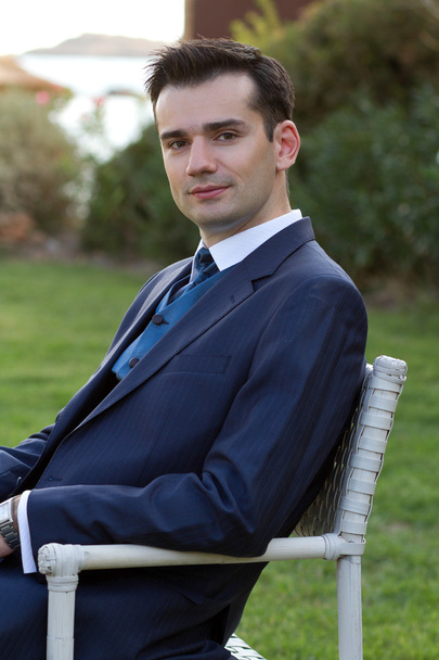 Young man in suit sitting outdoors - Φωτογραφία, εικόνα