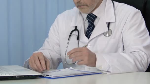 Professional therapist writing prescription for patient, keeping medical records - Video