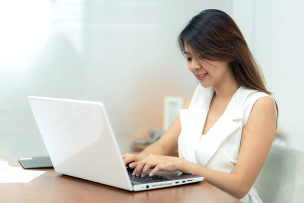 Asian woman smile while using laptop - Foto, imagen