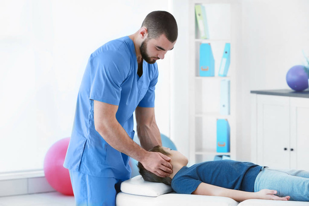Physiotherapist working with patient in clinic - Foto, imagen