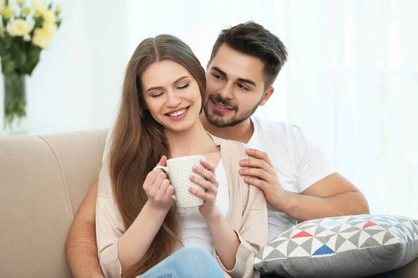 Young couple sitting on sofa - Foto, afbeelding