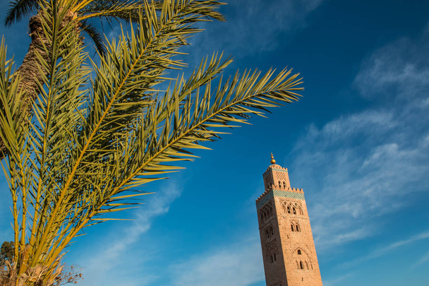 Koutoubia Mosque and palm at blue sky background - Photo, Image