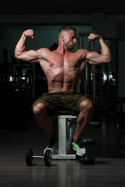 Young Bodybuilder Flexing Muscles - Foto, Imagen