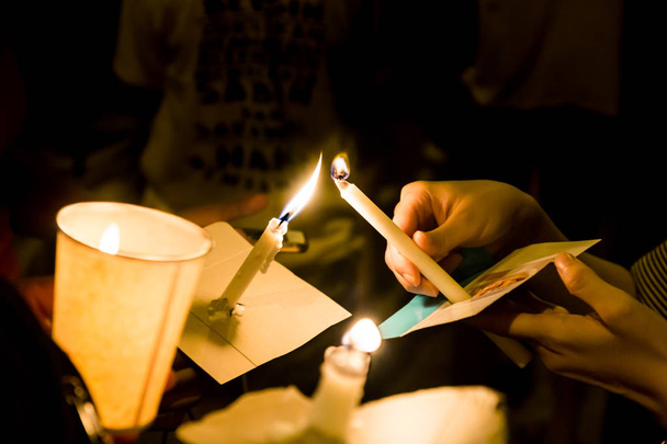 People lighting candle vigil in darkness seeking hope, worship,  - Photo, Image