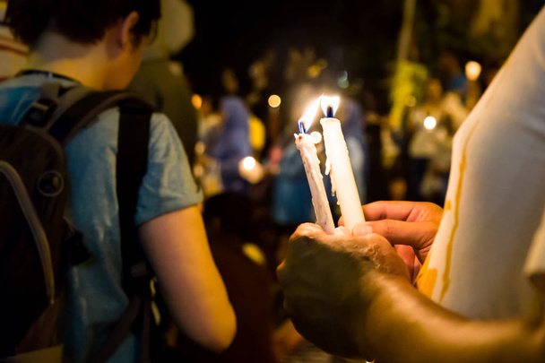Gente sosteniendo vigilia de velas en la oscuridad buscando esperanza, adoración, p
 - Foto, imagen