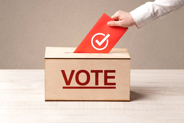 Close up of male hand putting vote into a ballot box - Foto, immagini