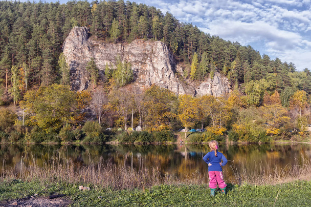 little girl stands on the bank of the Sylva river, on the other  - Foto, Bild