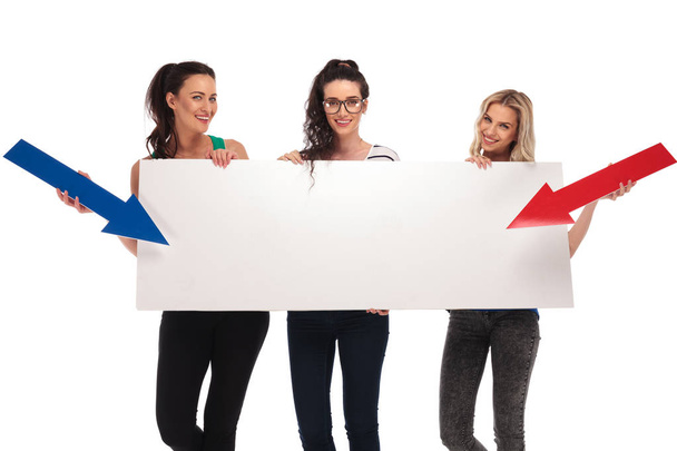 heureuses femmes occasionnelles pointant des flèches vers un grand tableau blanc
 - Photo, image
