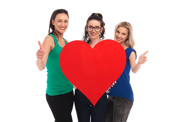 women holding a big heart and make the ok sign - Photo, Image