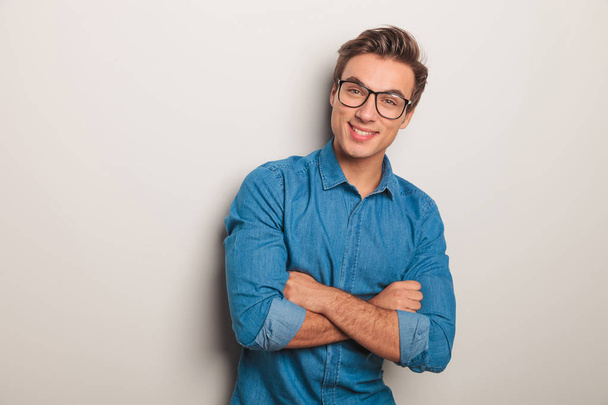 souriant homme décontracté portant des lunettes debout avec les mains croisées
  - Photo, image
