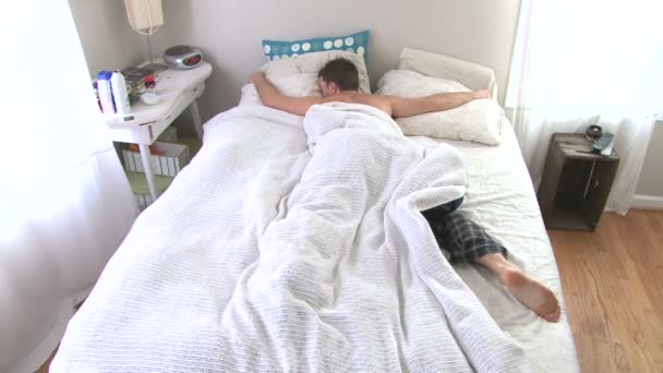 Man wakes up and hits snooze on alarm then goes back to sleep. - Footage, Video