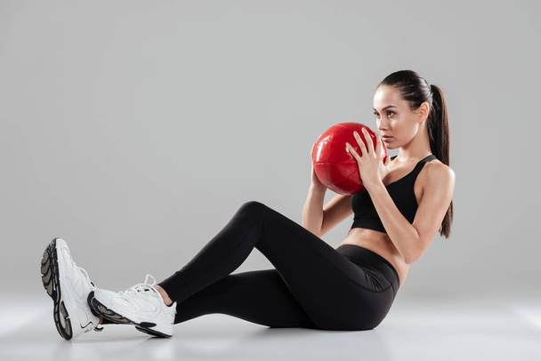 Volledige lengte van vrouw atleet uit te werken met de rode bal - Foto, afbeelding