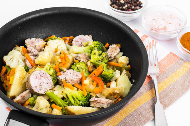 Рагу из овощей с колбасными ломтиками на сковородке на сковороде
 - Фото, изображение