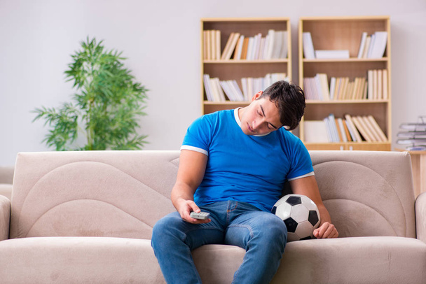 男見サッカーに家に座ってソファ - 写真・画像