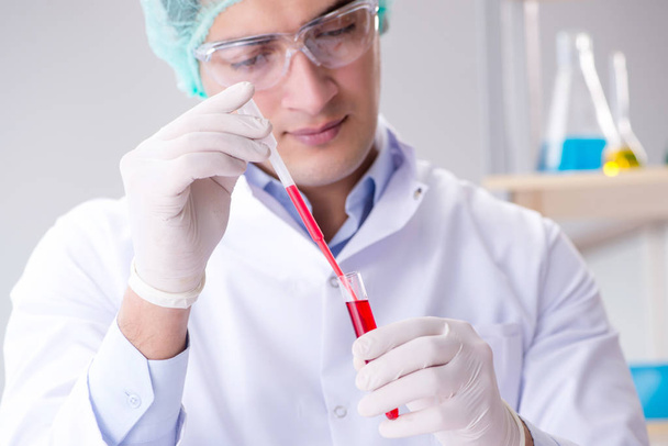 Tests sanguins en laboratoire avec un jeune scientifique - Photo, image