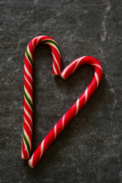 Candy Cane on a black marble background. Christmas background. - Foto, immagini