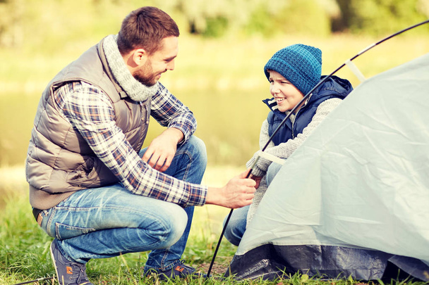happy father and son setting up tent outdoors - Φωτογραφία, εικόνα