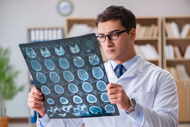 Молодой врач смотрит на компьютерную томографию рентгеновского изображения
 - Фото, изображение