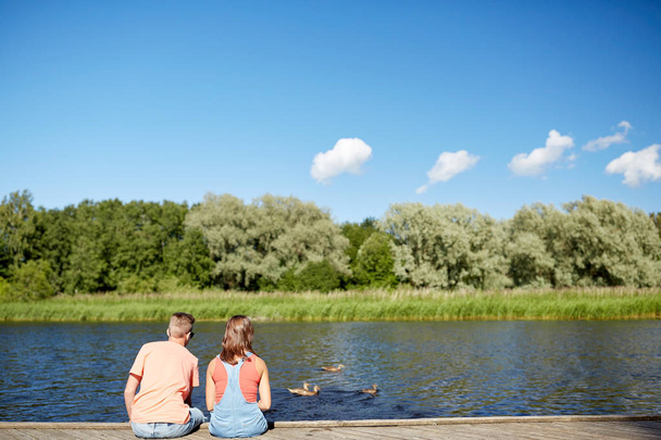 couple on river berth looking at swimming ducks - Foto, immagini