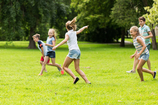 group of happy kids or friends playing outdoors - Valokuva, kuva