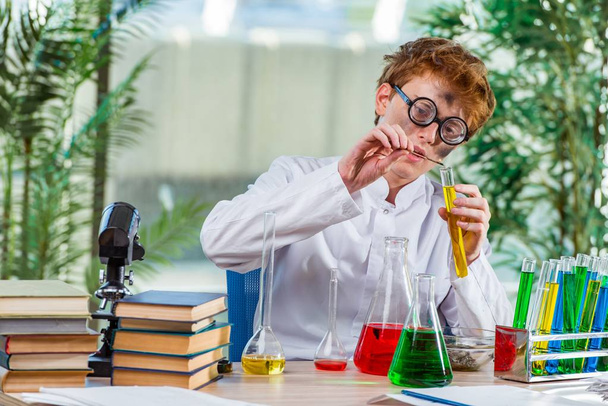 Giovane chimico pazzo che lavora in laboratorio
 - Foto, immagini