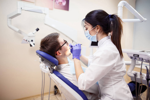 Female dentist checking patients teeth - Foto, immagini