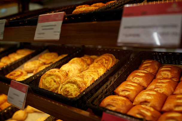 close up of buns at bakery or grocery store - Foto, afbeelding