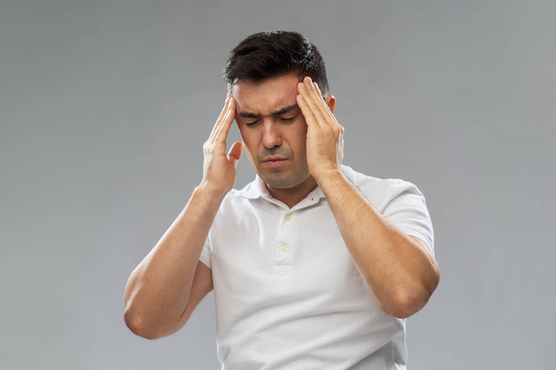 unhappy man suffering from head ache - Фото, изображение