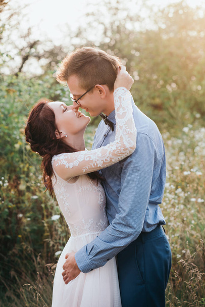 Sunshine portrait of happy bride and groom outdoor in nature location at sunset - Photo, image
