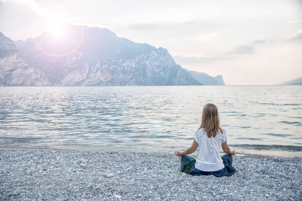 Woman meditating at the lake - Foto, Bild
